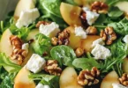 Apfel-Walnuss-Salat mit frischen Äpfeln und gerösteten Walnüssen auf einem Teller